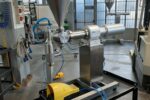 B.Mek – Dosatrice con tramoggia e accessori Macchina dosatrice con tramoggia e tubazioni in ambiente di officina